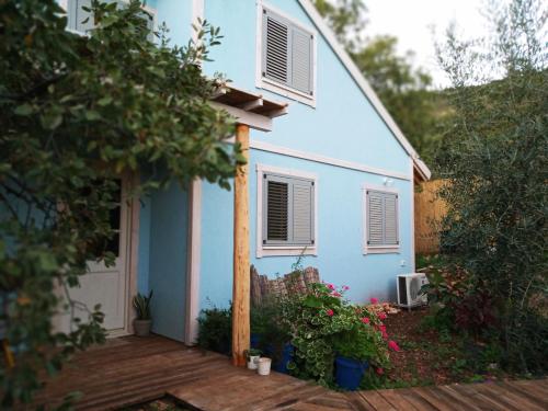 a blue house with a porch and a deck at Blue House In The Woods- Amirim in Amirim