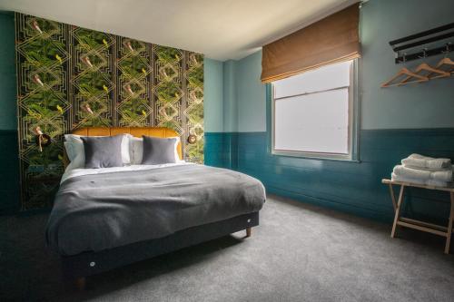 a bedroom with a large bed and a window at The Ship Rooms in London