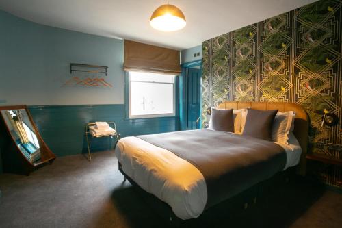 een slaapkamer met een groot bed en een raam bij The Ship Rooms in Londen