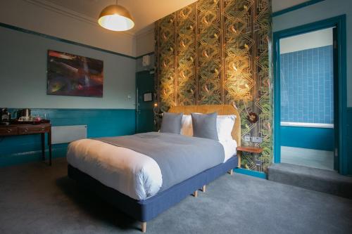 1 dormitorio con 1 cama grande y paredes azules en The Ship Rooms, en Londres