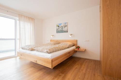 a bedroom with a bed in a room with a window at Ferienhof Haas in Friedrichshafen