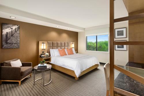 a bedroom with a bed and a couch and a chair at The Hotel at Arundel Preserve in Hanover