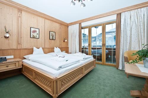 
a bedroom with a large bed and a large window at Wohlfühlhotel Garni KERSCHDORFER - adults only in Kaltenbach
