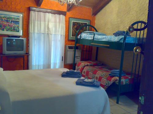 a bedroom with two bunk beds and a tv at Ianua Coeli 2 in Mosso Santa Maria