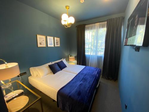 1 dormitorio con cama con sábanas azules y ventana en Hografic Hotel Boutique en Valencia