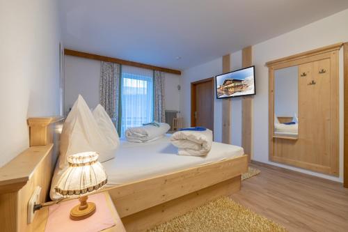 トレーポラッハにあるHotel Beim Winklerのベッドルーム(ベッド1台、ランプ、鏡付)