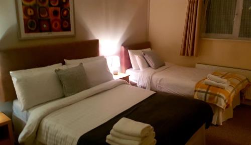 Habitación de hotel con 2 camas y toallas. en The Auld Triangle en Loughrea