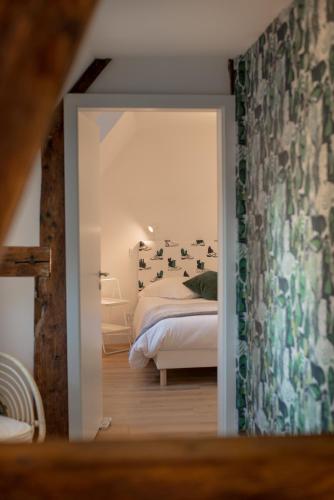 a bedroom with a bed and a door leading into a room at Les apparts du marché in Obernai