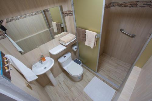 a bathroom with a toilet and a sink and a shower at Maytenus Galapagos in Puerto Ayora