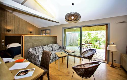 a living room with a couch and chairs at Les Glycines - Hôtel & Spa - Teritoria in Les Eyzies-de-Tayac