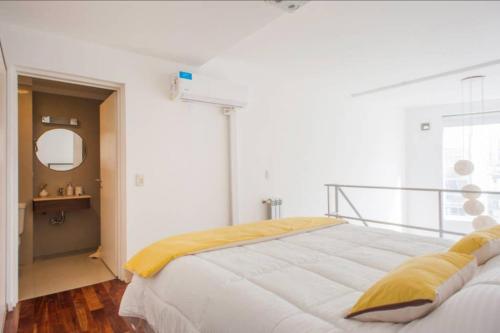 ブエノスアイレスにあるLuminosos Loft En Recoleta 2 Cuadras Del Subteのベッドルーム1室(大型ベッド1台、黄色い毛布付)