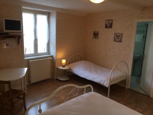 a small room with two beds and a window at Auberge Des Petits in Saint-Igny-de-Vers