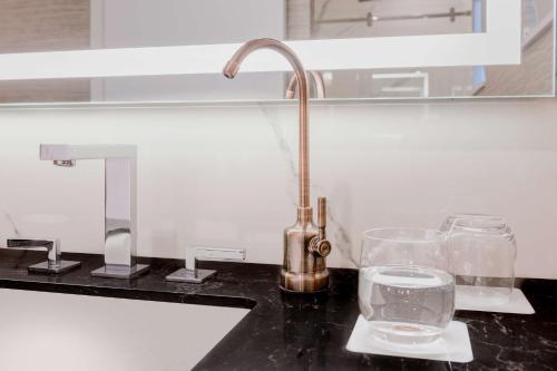 a kitchen counter with a sink and glasses on it at Hyatt Regency Calgary in Calgary