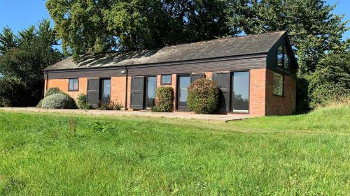 a small brick house on a grass field at Hayloft Cottage - Dog Friendly With Private Garden in Sidmouth