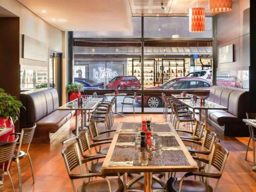 a restaurant with tables and chairs and cars in the background at ibis Wellington in Wellington