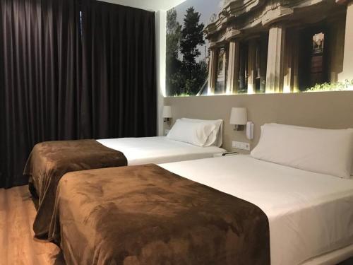 
a hotel room with a bed and two lamps at Hotel BESTPRICE Gracia in Barcelona
