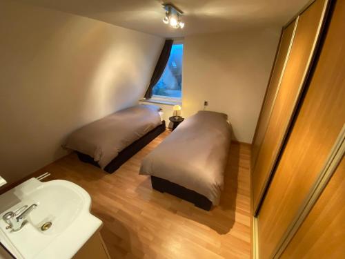 La salle de bains est pourvue de 2 lits et d'un lavabo. dans l'établissement Lake house 21 relax accommodation iR Sauna, à Warmond