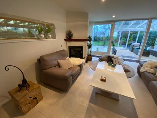 a living room with a couch and a table at Lake house 21 relax accommodation iR Sauna in Warmond