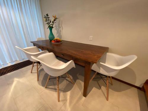 a wooden table with white chairs and a vase on it at Lake house 21 relax accommodation iR Sauna in Warmond