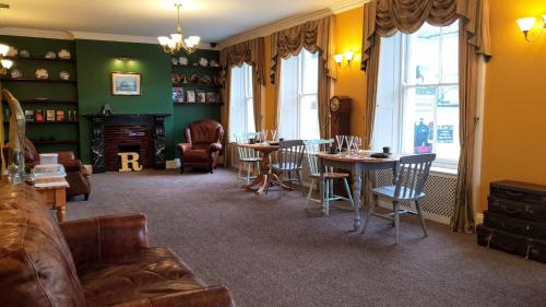 uma sala de estar com um sofá, mesas e cadeiras em Station House, Dartmoor and Coast located, Village centre Hotel em South Brent