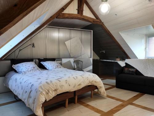 1 dormitorio con 1 cama grande y 1 sofá negro en Le Chêne creux en Sucé