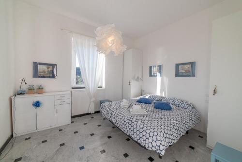 ein weißes Schlafzimmer mit einem Bett und einem Fenster in der Unterkunft Cosy Apartment by PortofinoVip in Rapallo