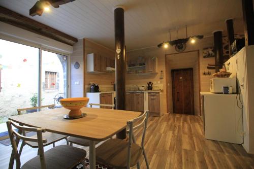 uma cozinha e sala de jantar com mesa e cadeiras em lecurieabedous em Bedous