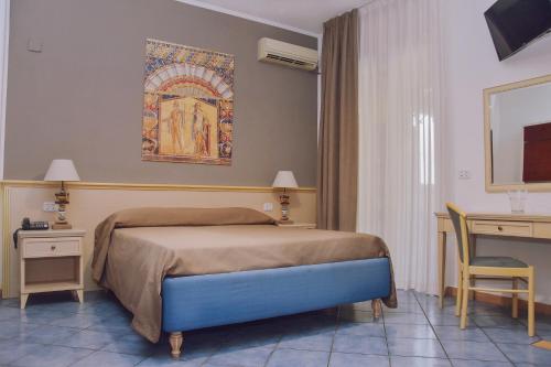 a bedroom with a bed and a desk with a computer at Hotel Piccolo Sogno in Pompei
