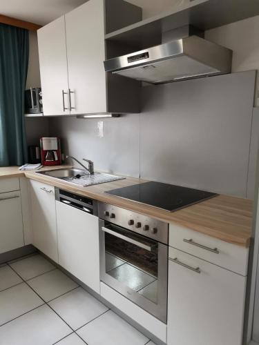 a kitchen with white cabinets and a stove top oven at Ferienlandhaus Höfer in Fulpmes