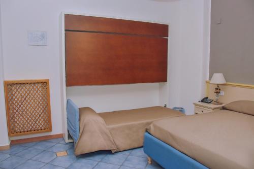 a hotel room with two beds and a window at Hotel Piccolo Sogno in Pompei