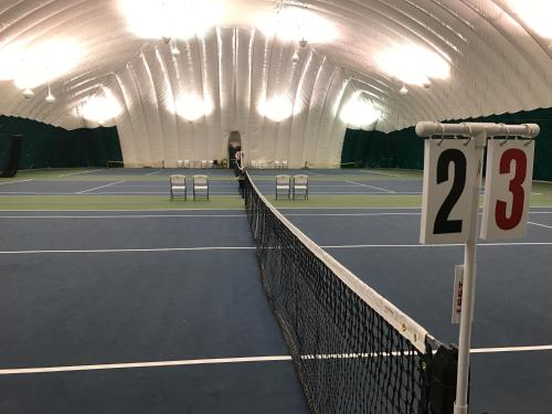 a tennis court with a net with the number at The Grand Resort in Howland Corners