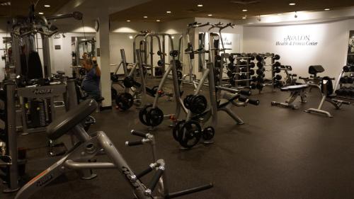 a gym with lots of machines and a woman in the background at The Grand Resort in Howland Corners