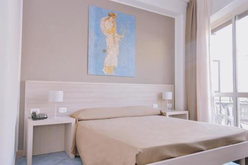 a bedroom with a bed and a painting on the wall at Hotel Piccolo Sogno in Pompei