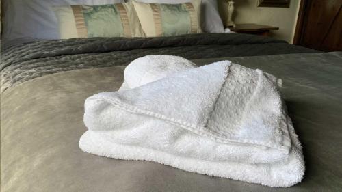 a white towel sitting on top of a bed at Mill House - Devon Holiday Accommodation in Sidmouth