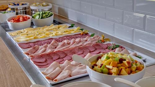 ein Buffet mit vielen verschiedenen Fleischsorten und Käse in der Unterkunft Holiday Inn Express Dortmund, an IHG Hotel in Dortmund