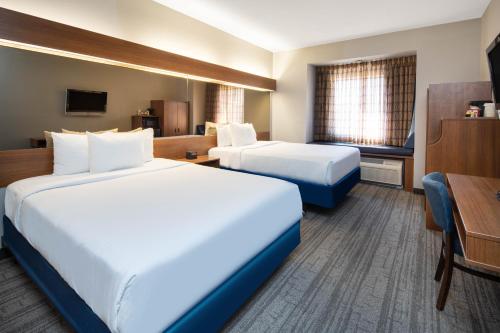 a hotel room with two beds and a desk at Baymont by Wyndham Las Vegas South Strip in Las Vegas
