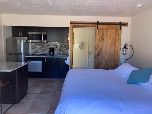 a bedroom with a large bed and a kitchen at Red Agave Resort in Sedona
