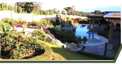 a backyard with a swimming pool and a garden at Villa El Retiro Luxury Property in Alajuela City