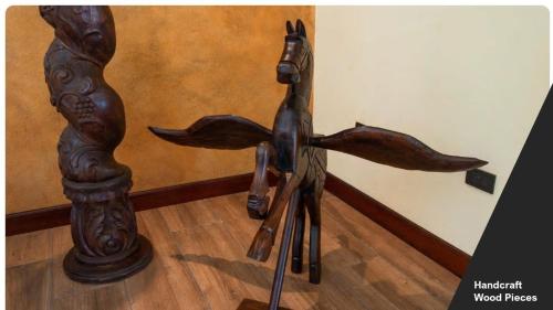 a wooden statue of a horse on a wooden floor at Villa El Retiro Luxury Property in Alajuela City