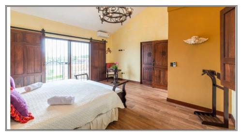 a bedroom with a large bed and a large window at Villa El Retiro Luxury Property in Alajuela City
