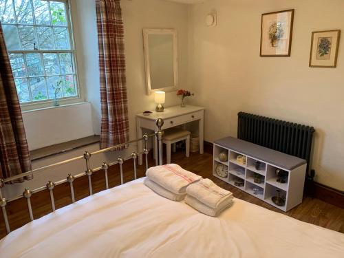 a bedroom with a bed and a table and a window at Charming Devon Cottage near Quay-Rain Shower, Restaurants & Free Parking in Kingsbridge
