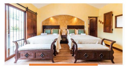 a bedroom with two beds and two chairs at Villa El Retiro Luxury Property in Alajuela City