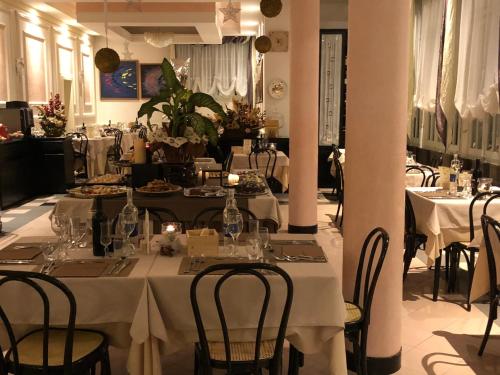 un comedor con mesas y sillas con mantel blanco en Hotel Montepizzo, en Lizzano in Belvedere