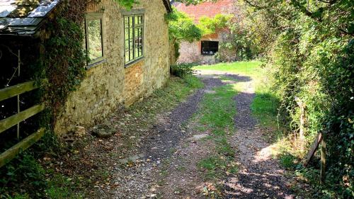 a dirt road next to an old stone building at The Grannary in Sidmouth