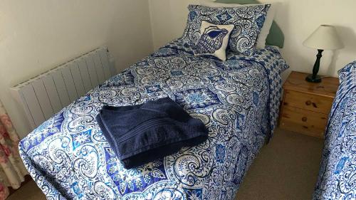 a bed with blue and white sheets and pillows at The Grannary in Sidmouth
