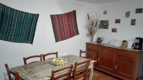 a dining room with a table and chairs and a kitchen at GITE Le CERISIER VIA RHONA DOLCE VIA in La Voulte-sur-Rhône