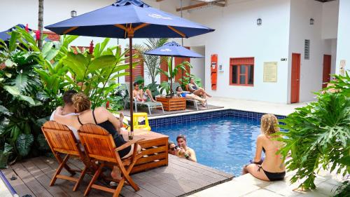 a group of people sitting in chairs next to a pool at La Vaina Cali in Cali