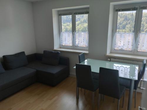 a living room with a couch and a table and chairs at Four Seasons Apartment Josef in Eisenerz