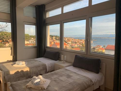 2 łóżka w pokoju z dużymi oknami w obiekcie Duplex Apartment with Private Swimming Pool w mieście Preko