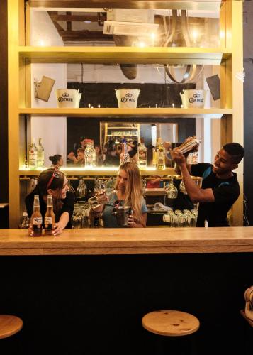 a group of people sitting at a bar at La Vaina Cali in Cali